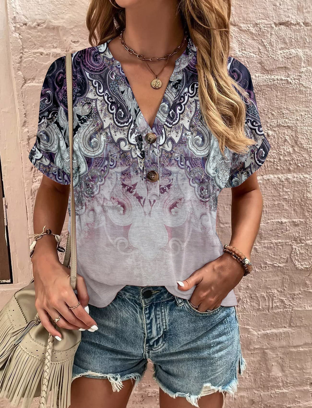 Women's casual short-sleeved blouse with a playful paisley pattern and modern button details, size S
