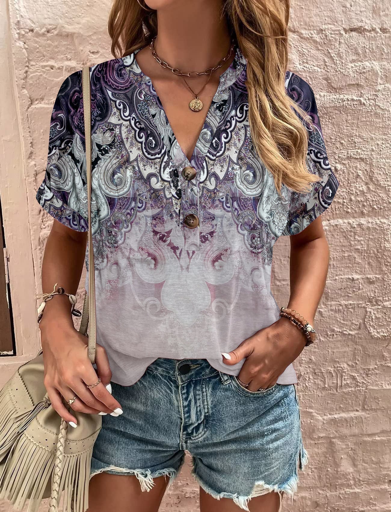 Women's casual short-sleeved blouse with a playful paisley pattern and modern button details, size S