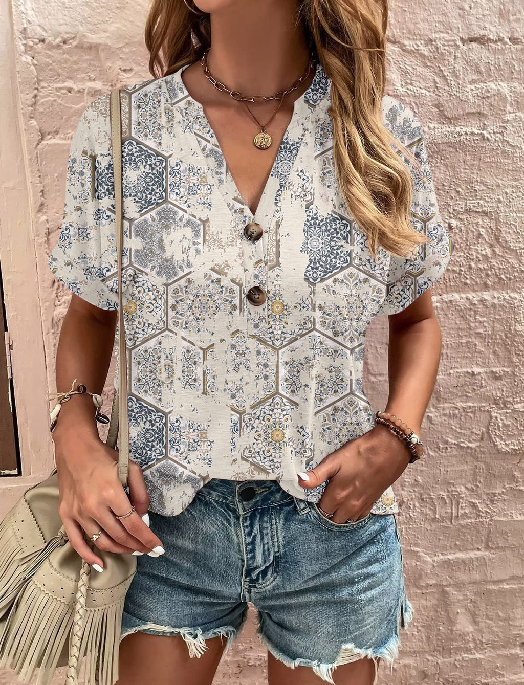 Women's casual short-sleeved blouse with a playful paisley pattern and modern button details, size S